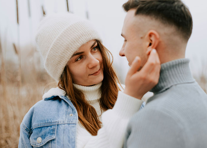 Woman warmly interacting with a man in a winter setting, reflecting struggles men wish women knew.