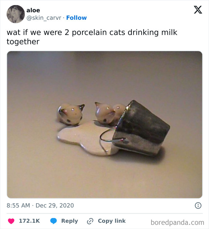 Porcelain cats humorously drinking milk from a small tipped bucket.