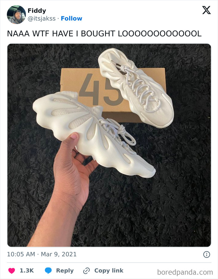 Person holding unique white shoes, seeming to regret a purchase decision.