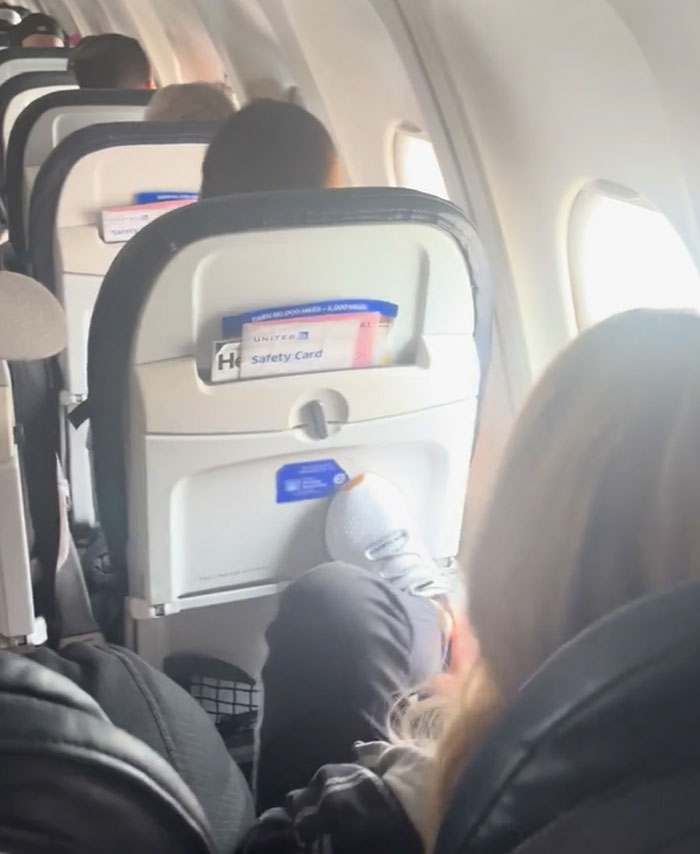 Passenger on plane with feet up, causing discomfort to others; an example of annoying plane passengers.