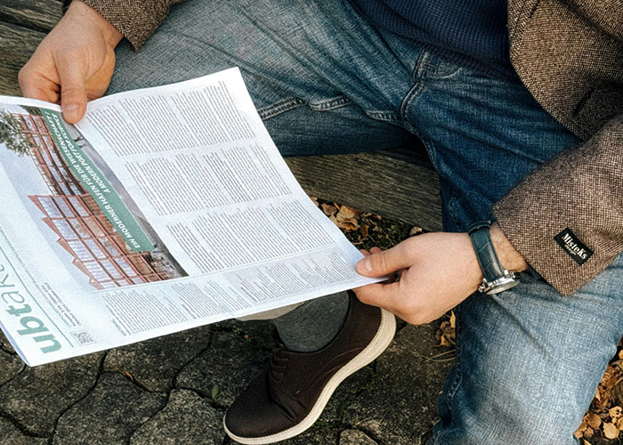 Man in casual attire reading a newspaper, illustrating struggles men wish women knew.