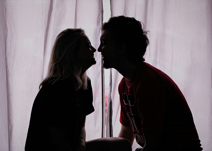 Silhouetted couple facing each other, illustrating struggles men wish women knew.