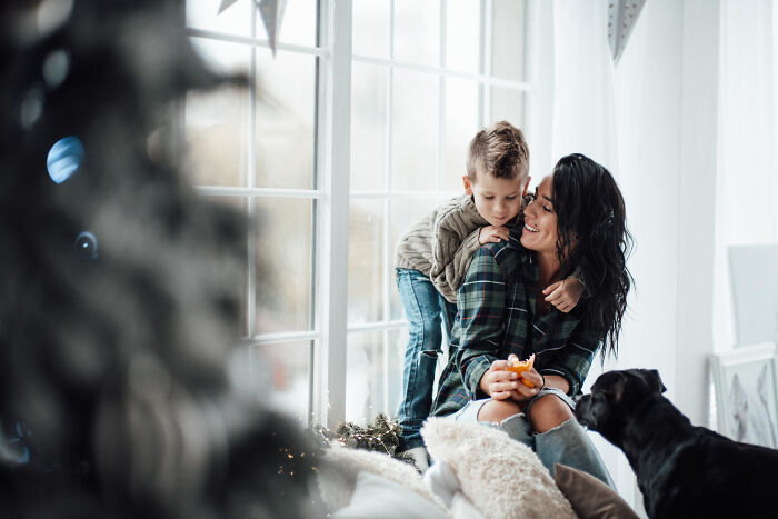A woman and child smile near a window with a black dog, reflecting a risky decision moment.