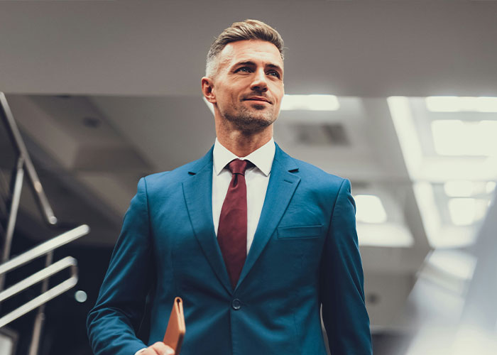 Confident man in a business suit holding a folder, reflecting struggles men wish women knew.