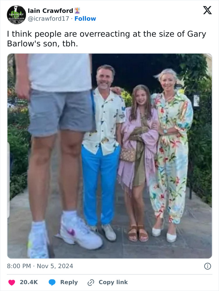 Gary Barlow's son stands tall, overshadowing a group in a comical meme-worthy moment.