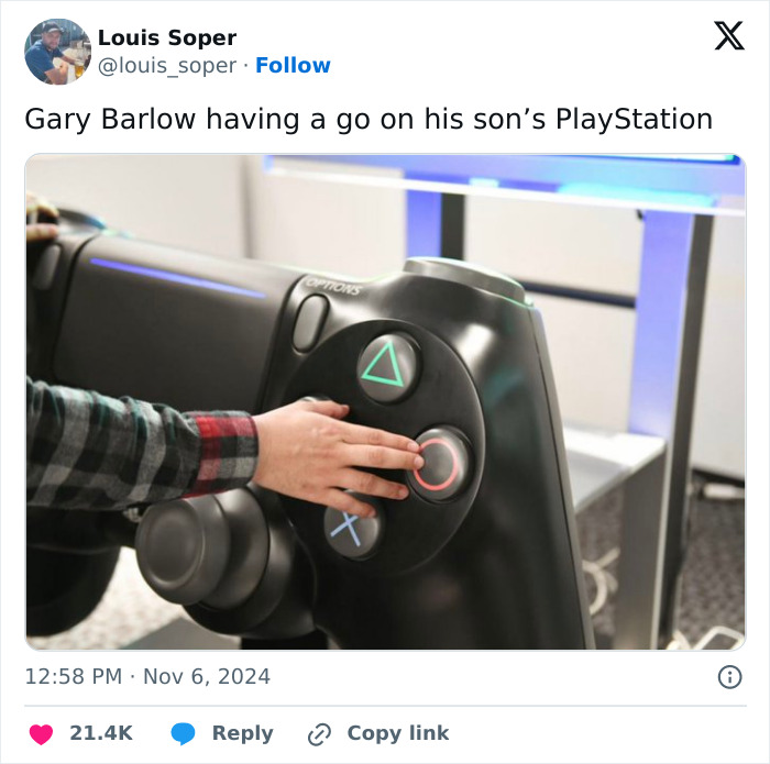 Gary Barlow's son playfully using a giant PlayStation controller, humorously highlighting his towering height.