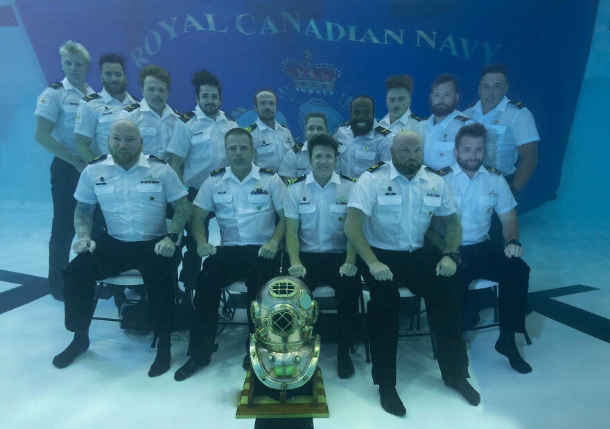Royal Canadian Navy members in uniform posing underwater with a historic diving helmet, showcasing pics that go hard.