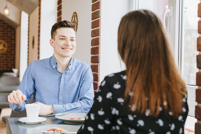 A man and woman having a conversation over coffee, representing a risky decision discussion.