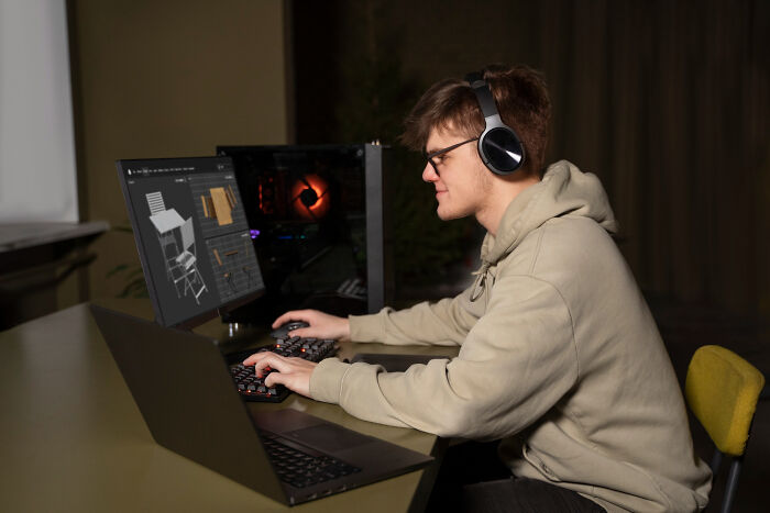 Person in hoodie using a computer with headphones on, illustrating a risky decision-making process and its outcome.