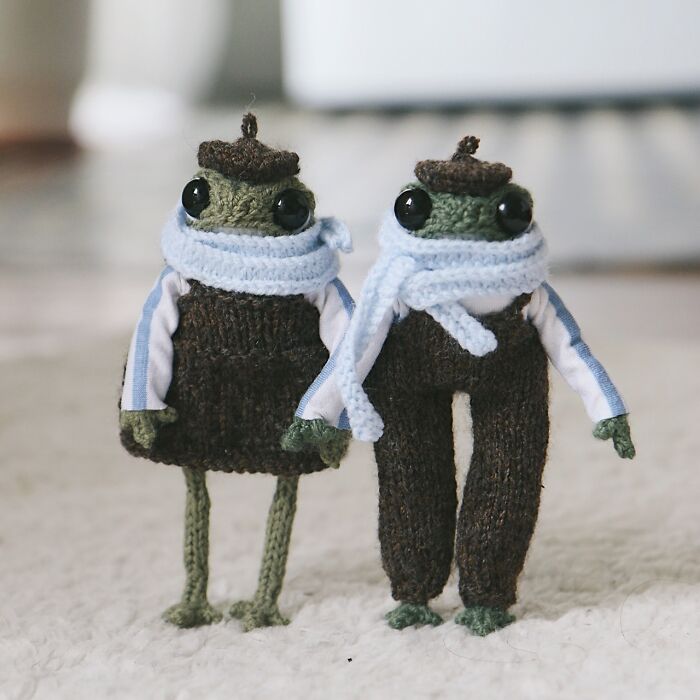 Two cute miniature knitted frogs wearing berets and scarves, crafted by a French knitter.