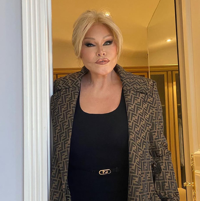 Jocelyn Wildenstein in designer outfit, standing in a doorway. Jocelyn Wildenstein in designer outfit, standing in a doorway.