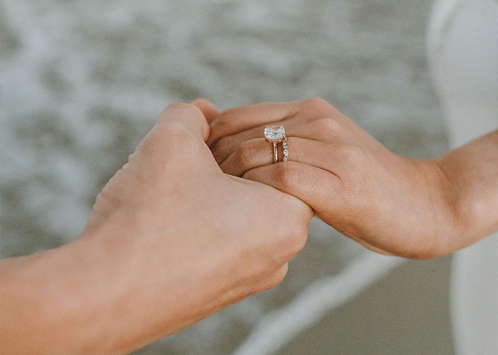 Hands holding with a wedding ring, symbolizing marriage and divorce reasons.