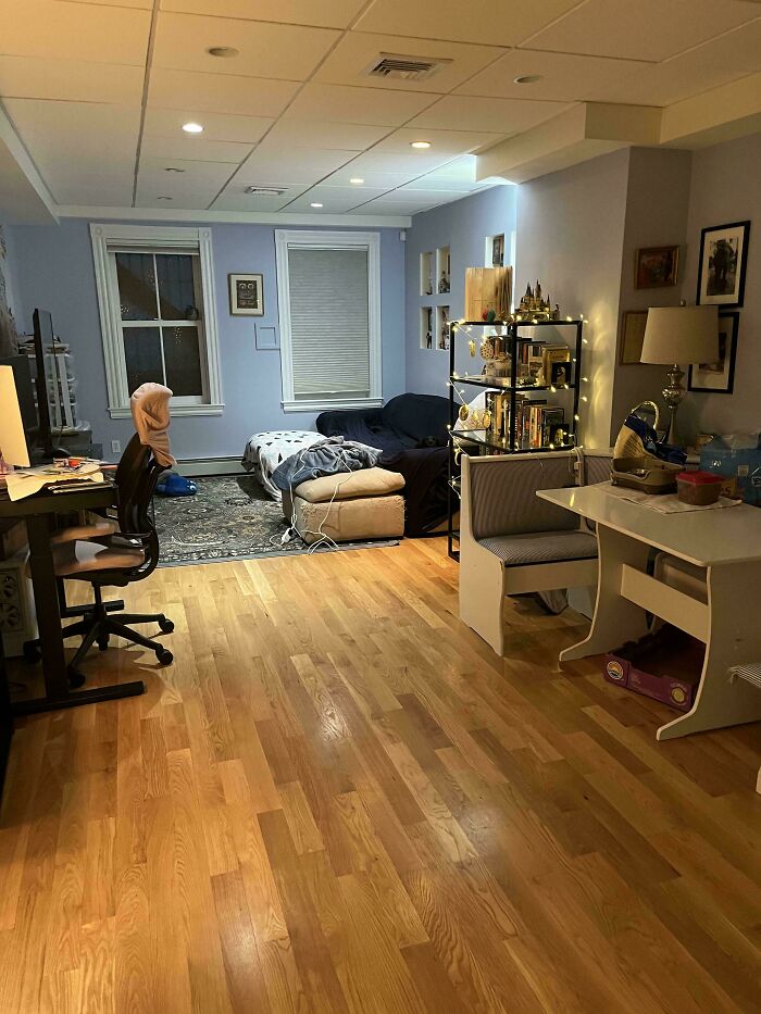 A cozy room with objects seamlessly merging into the background, featuring wooden floors, a desk, and a couch.