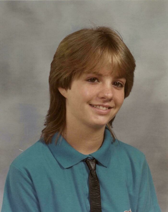 Teen in a school photo wearing a blue shirt and tie, capturing a moment from their blunder years.