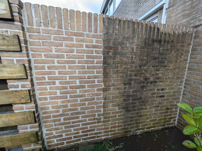 Power washed brick wall, half cleaned showing satisfying contrast between dirty and clean surfaces.