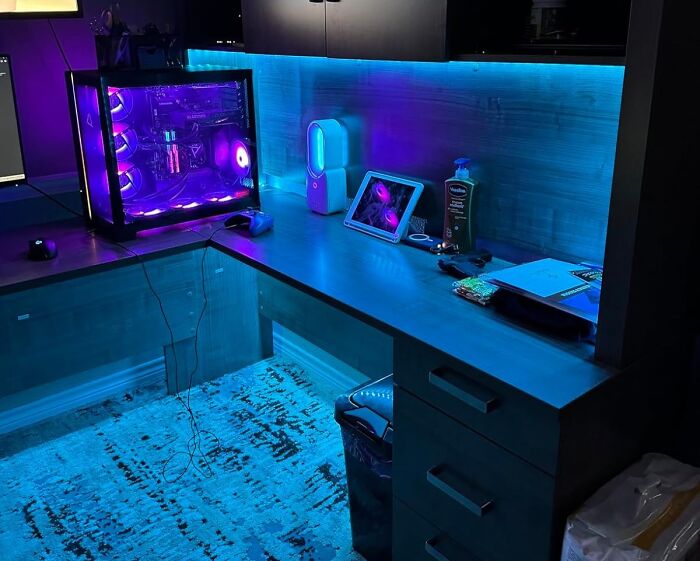 Gaming setup with purple LED lights, computer tower, tablet, and accessories on a modern desk for shopping for a 12-year-old.