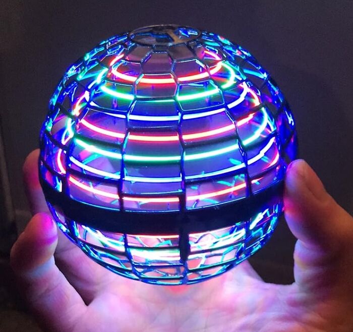 Hand holding a glowing, colorful LED toy sphere, perfect for shopping for a 12-year-old gift ideas.