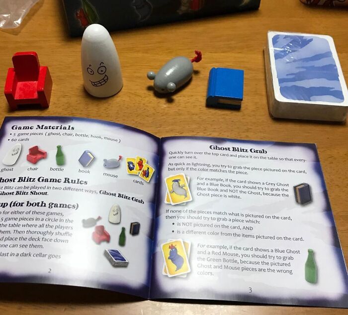 Board game pieces including ghost, chair, bottle, book, and mouse with cards and instructions for compact and straightforward games.