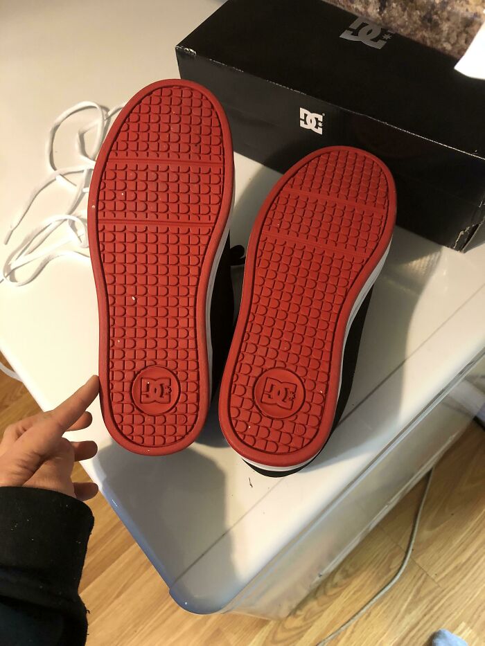 Red rubber soles of DC shoes shown from underneath; online shopping fail.