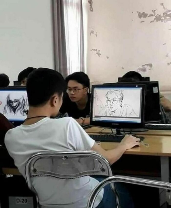 Student in a classroom drawing a seated classmate on a computer screen, capturing a unique artistic moment.