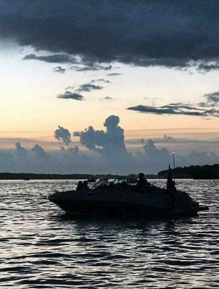Boat on a lake at dusk with fascinating cloud shapes in the sky.