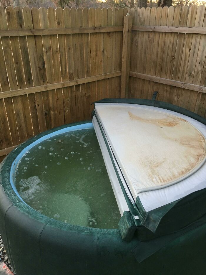 Inflatable hot tub with murky water in a wooden fenced yard, representing regrettable spending.
