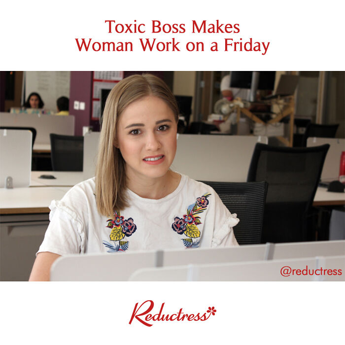 Woman working at desk with a concerned expression, reflecting humor from fake headlines.