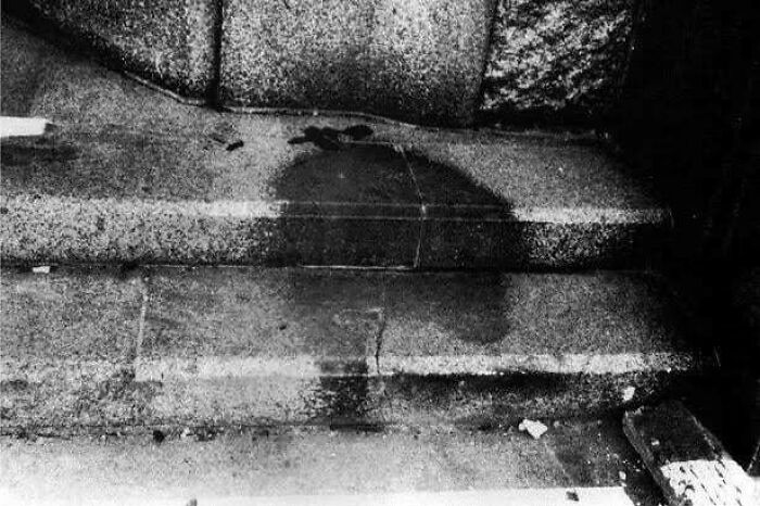 Black and white image of concrete steps, stained with dark, irregular shapes. A creepy image showing hair of kids.