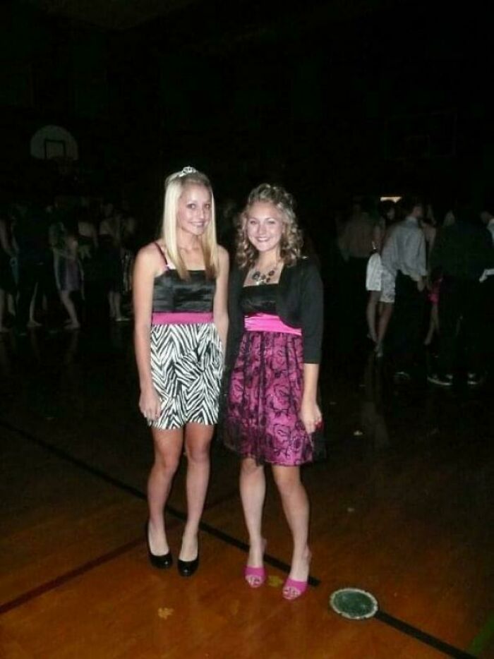Two young women at a dance, wearing patterned dresses and heels, capturing a blunder years moment.