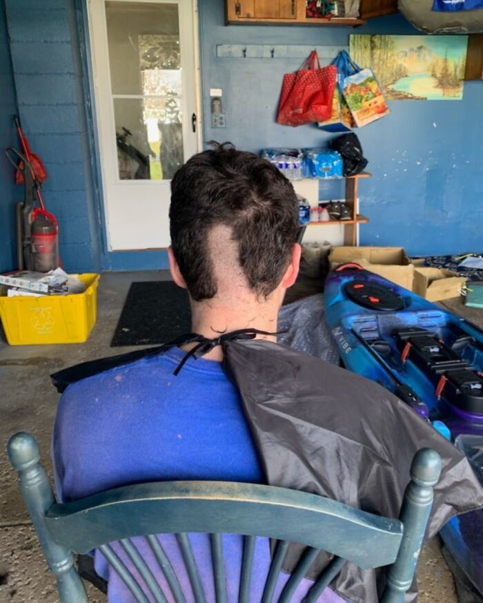 Back view of a botched haircut with uneven patches, illustrating hair-cutting-dyeing-fails in a cluttered room.