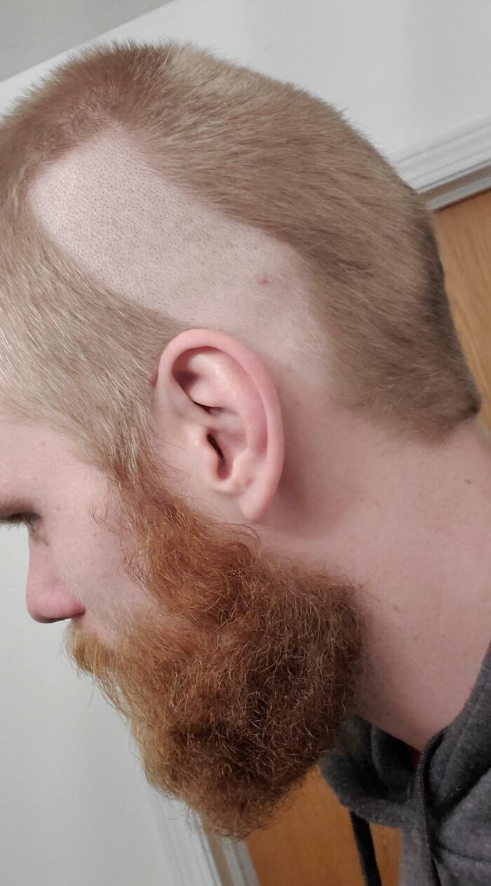 A young man with an uneven haircut showcasing a hair-cutting-dyeing-fail in a home setting.