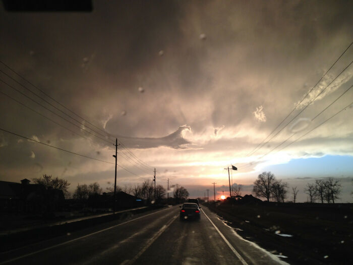 Highway at sunset with fascinating cloud shapes, showcasing a dramatic sky surprise.