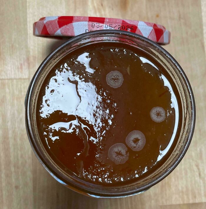 Jar with mold spots on the syrup surface, causing mild irritation.