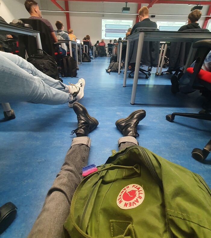 Seated student observing a classroom presentation, showcasing regretted spending decision.