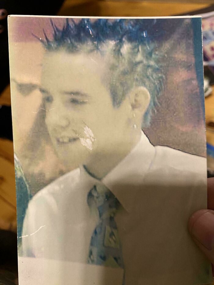 Young person with spiky hair, wearing a white shirt and patterned tie, representing a blunder years moment.