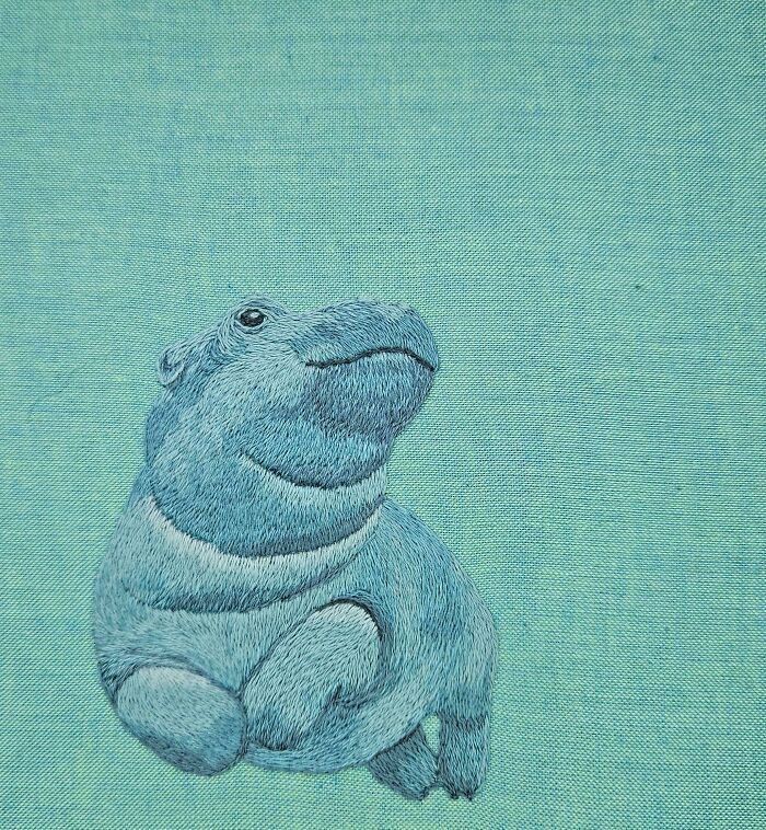 Blue hippo embroidery design with detailed stitching on textured fabric showcasing beautiful embroidery designs.