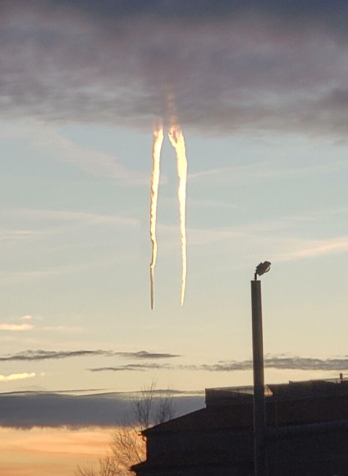 Fascinating cloud shapes resembling two vertical streaks against a sunset sky.