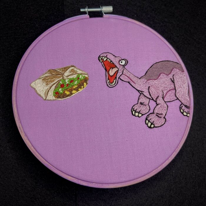 Purple embroidery hoop featuring a detailed dinosaur and taco design, showcasing creative and beautiful embroidery designs.