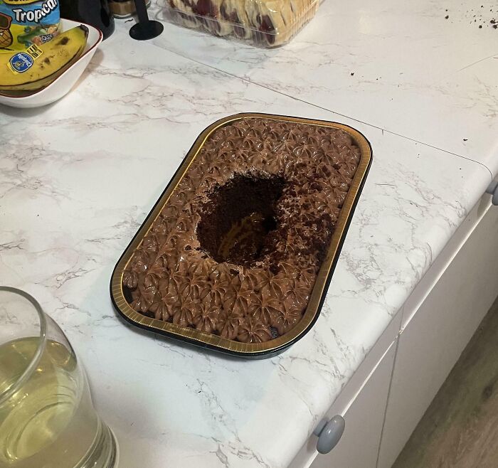 Chocolate cake with a large scoop missing in a kitchen setting, highlighting infuriating habits.