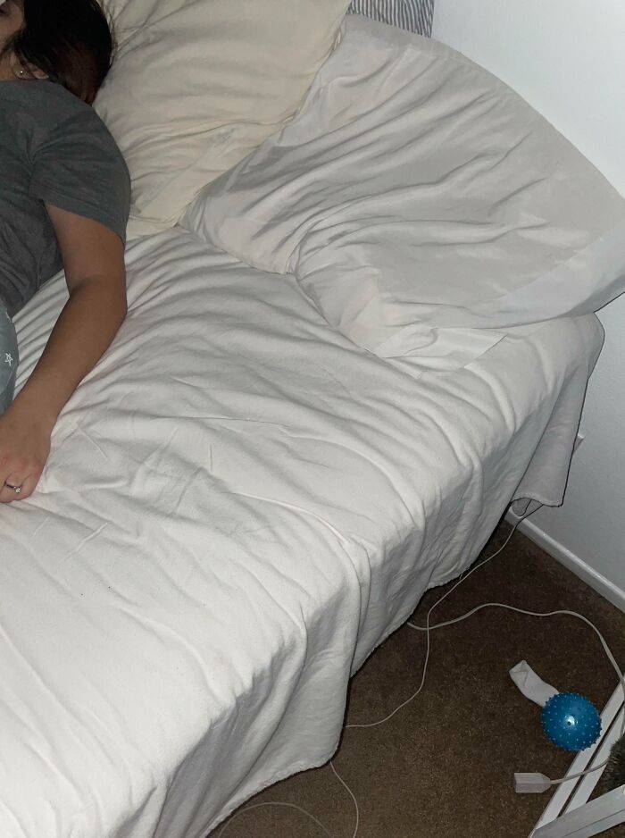 Woman taking up most of the bed, leaving little room for her partner, illustrating infuriating wives or girlfriends scenarios.