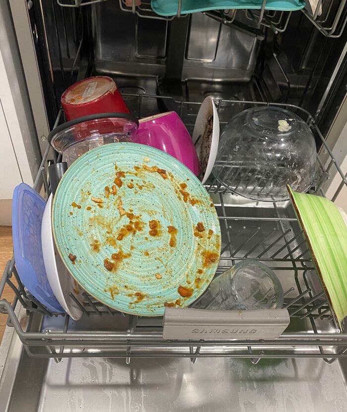 Messy dishwasher with dirty dishes, illustrating infuriating situations in household chores.