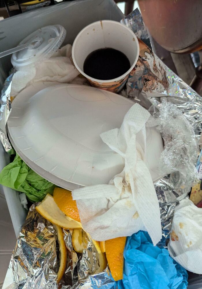 Messy kitchen trash with orange peels and a messy coffee cup lid, reflecting daily chaos in relationships.