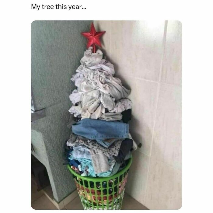 Laundry piled into a Christmas tree shape with a red star on top, humorously showing barely holding it together.
