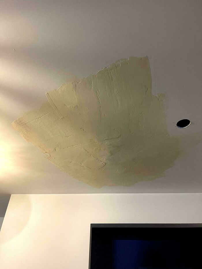Ceiling with uneven plaster patch and hole, illustrating a home improvement fail.