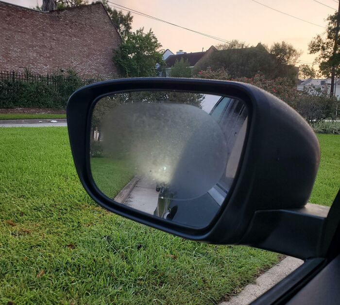 Foggy car side mirror reflecting regretful spending decision.