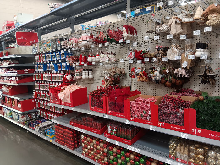 Holiday decorations displayed out of season, featuring Christmas ornaments and decorations in a shopping aisle.