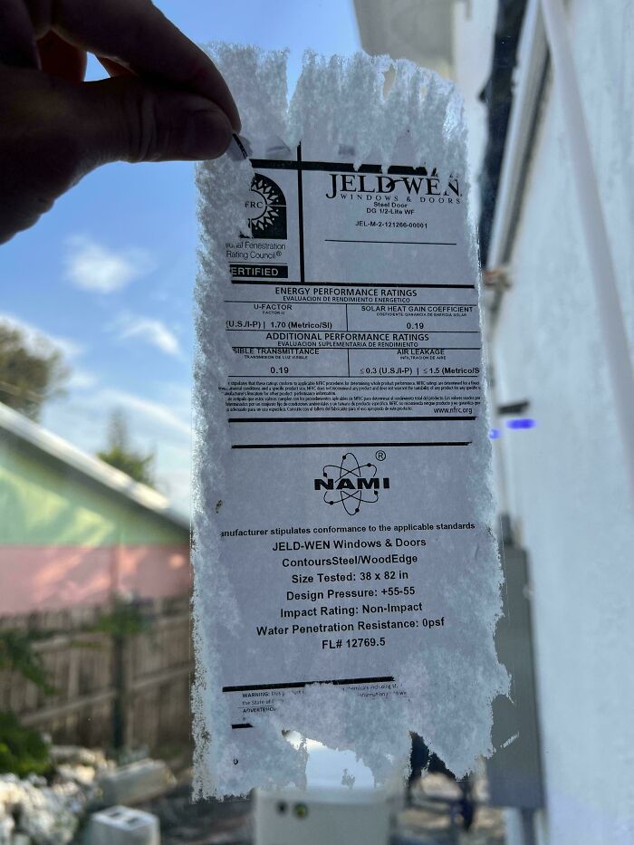 Torn window label held up to the light, showcasing mildly infuriating imperfections.