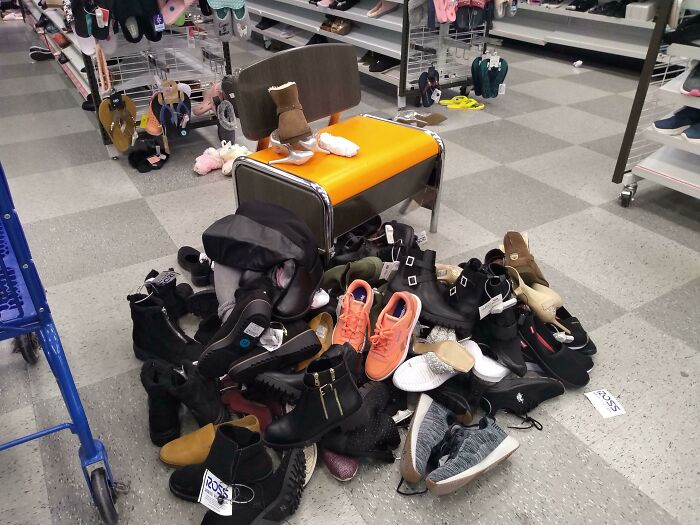 Chair piled with shoes in a store aisle, illustrating inconsiderate behavior.