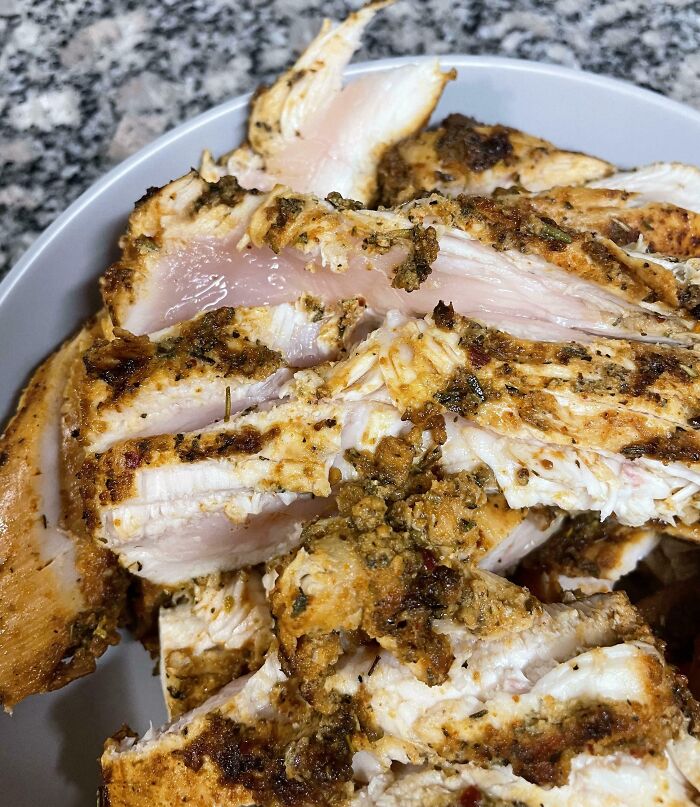 Undercooked chicken slices on a plate, possibly a meal made by boyfriends or husbands.