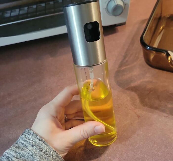 Hand holding an affordable kitchen oil sprayer on countertop showing budget-friendly home finds for easy living.